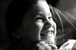 Delightful black and white portrait of a smiling child exhibiting pure joy and happiness.