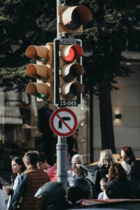 Urban street scene with group of pedestrians and traffic lights in downtown setting.