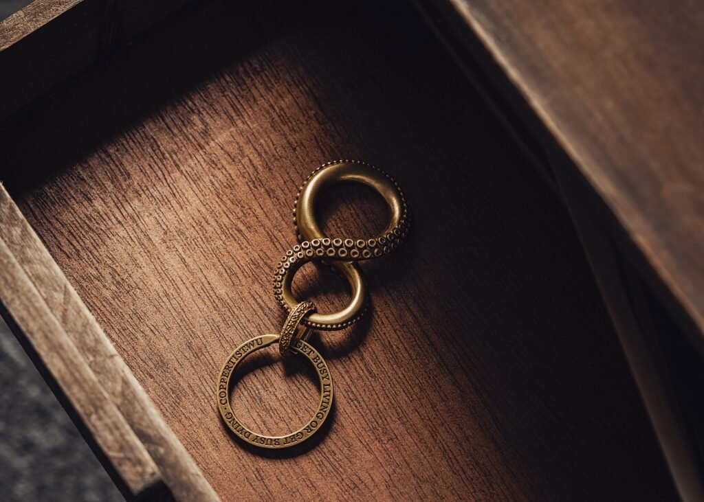 Close-up of an ornate brass infinity keychain on a wooden background, evoking a sense of elegance and mystery.