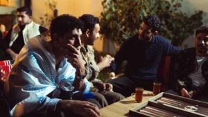 Group of friends enjoying an evening with tea and a board game indoors.