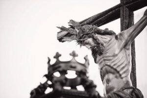 A dramatic close-up of a crucifix statue outdoors in Carmona, Spain, highlighting religious symbolism.