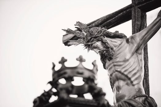 A dramatic close-up of a crucifix statue outdoors in Carmona, Spain, highlighting religious symbolism.